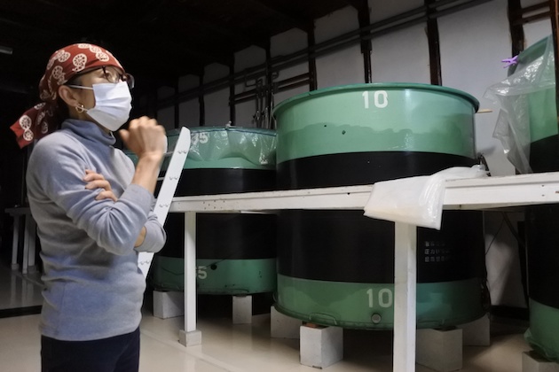 タンクの前で説明する今田さん