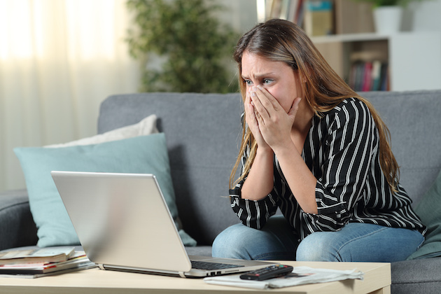 PCの前でショックを受ける女性