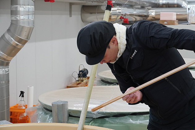 タンク内のもろみの様子を見る伊東さん