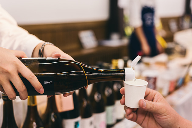 紙コップに注がれる日本酒