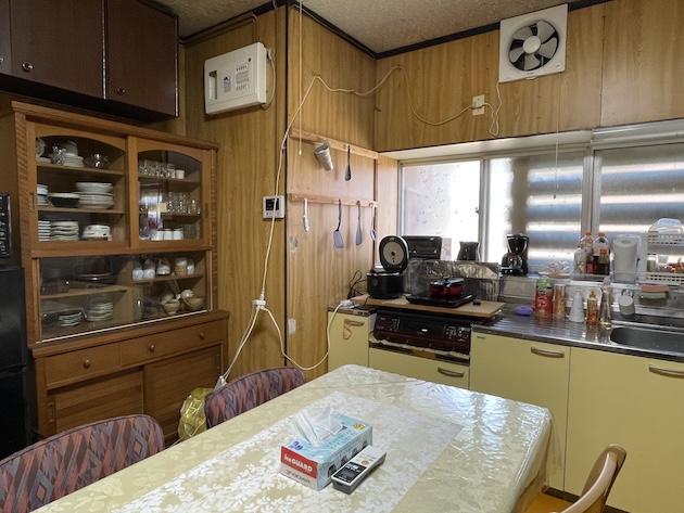 食器棚やテーブル、調理器具等が置かれた古民家のキッチン写真