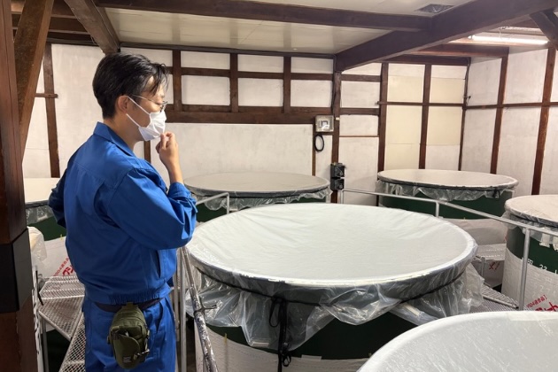 醸造タンクの前に立つ梁瀬一真さん