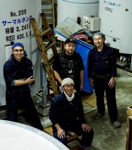 タンクの前に立つ製造チームの集合写真