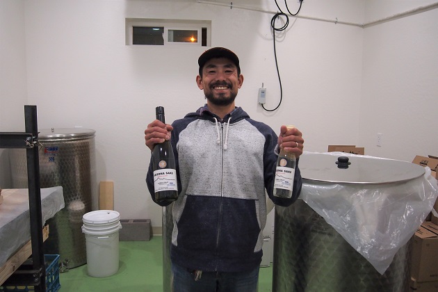 Mr. Sakurai holding up a bottle of "My Sake"