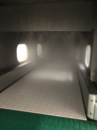 Inside pasteurizer. Bottles move through the machine on the conveyor as they get showered by hot and then cold water. (2)